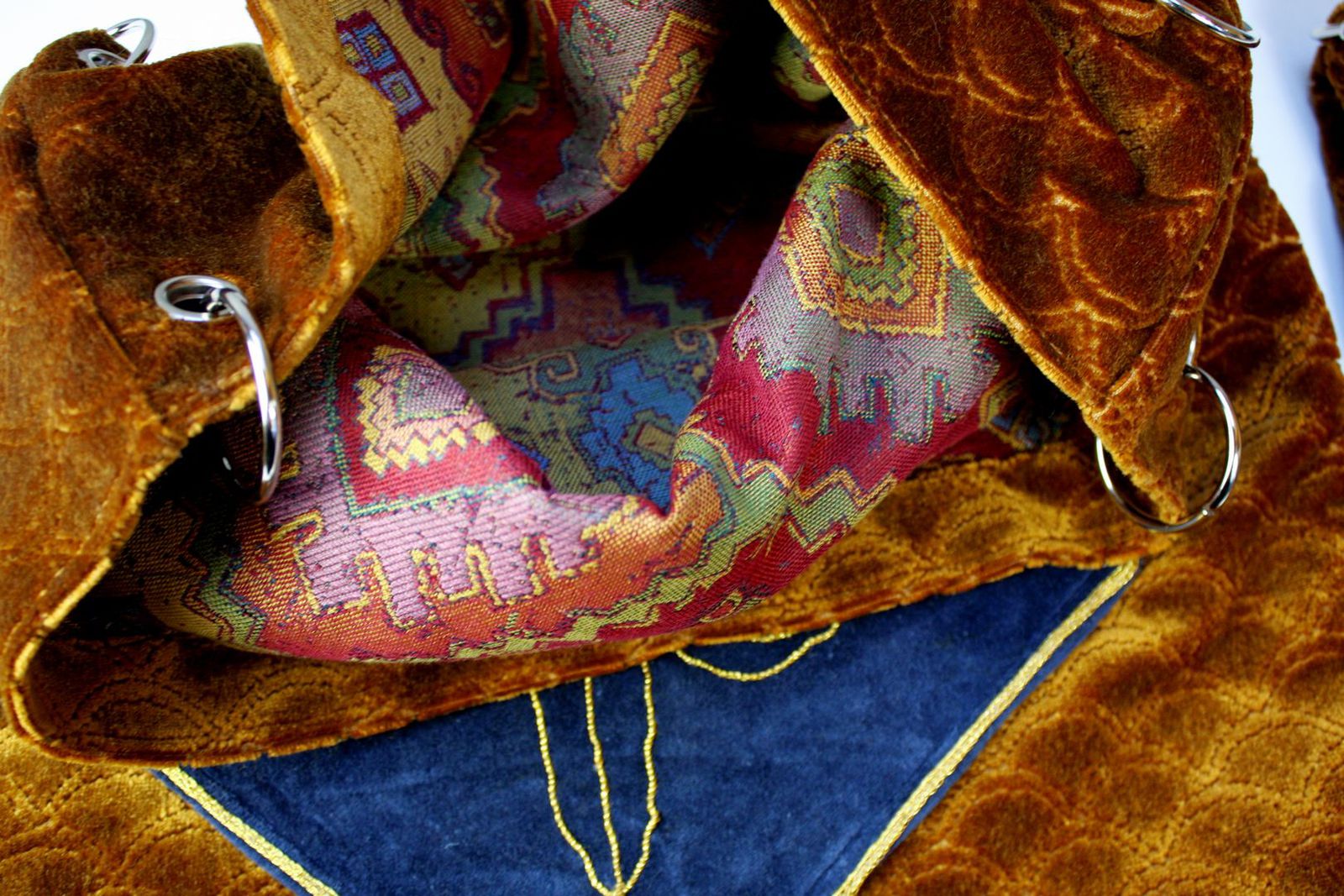 Wnętrze torby worka z materiałów obiciowych: złotego strukturalnego weluru i kolorowego żakardu.