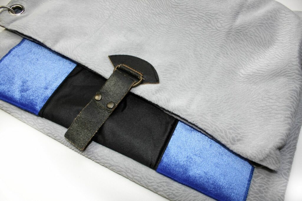 Szara torebka z weluru na ramię z atlasową kieszenią i skórzaną klamerką.