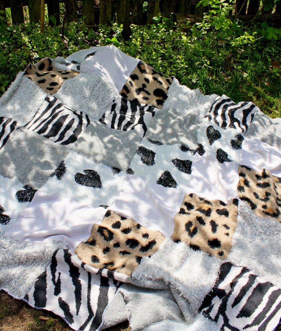 Patchworkowy koc sawanna rozłożony na trawie, elementy swetrów w paski zebry i cętki tygrysa.